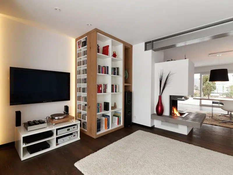 Bücherschrank mit Regalen neben einem Fernseher und einem Kamin in einem Wohnraum