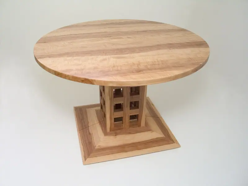 Runder Tisch mit gemusterter Platte und Fuß aus Holz