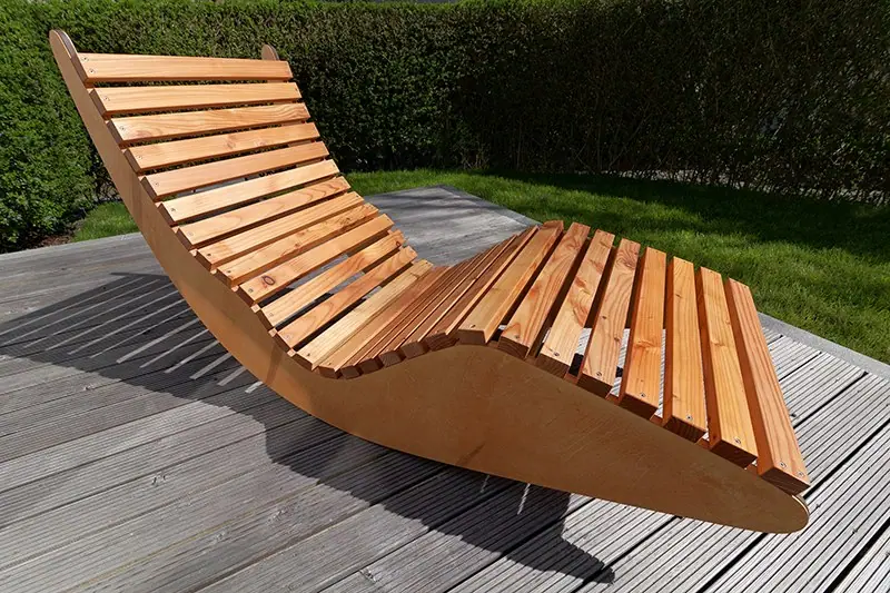 Geschwungene Relaxliege aus Holz auf einer Terrasse